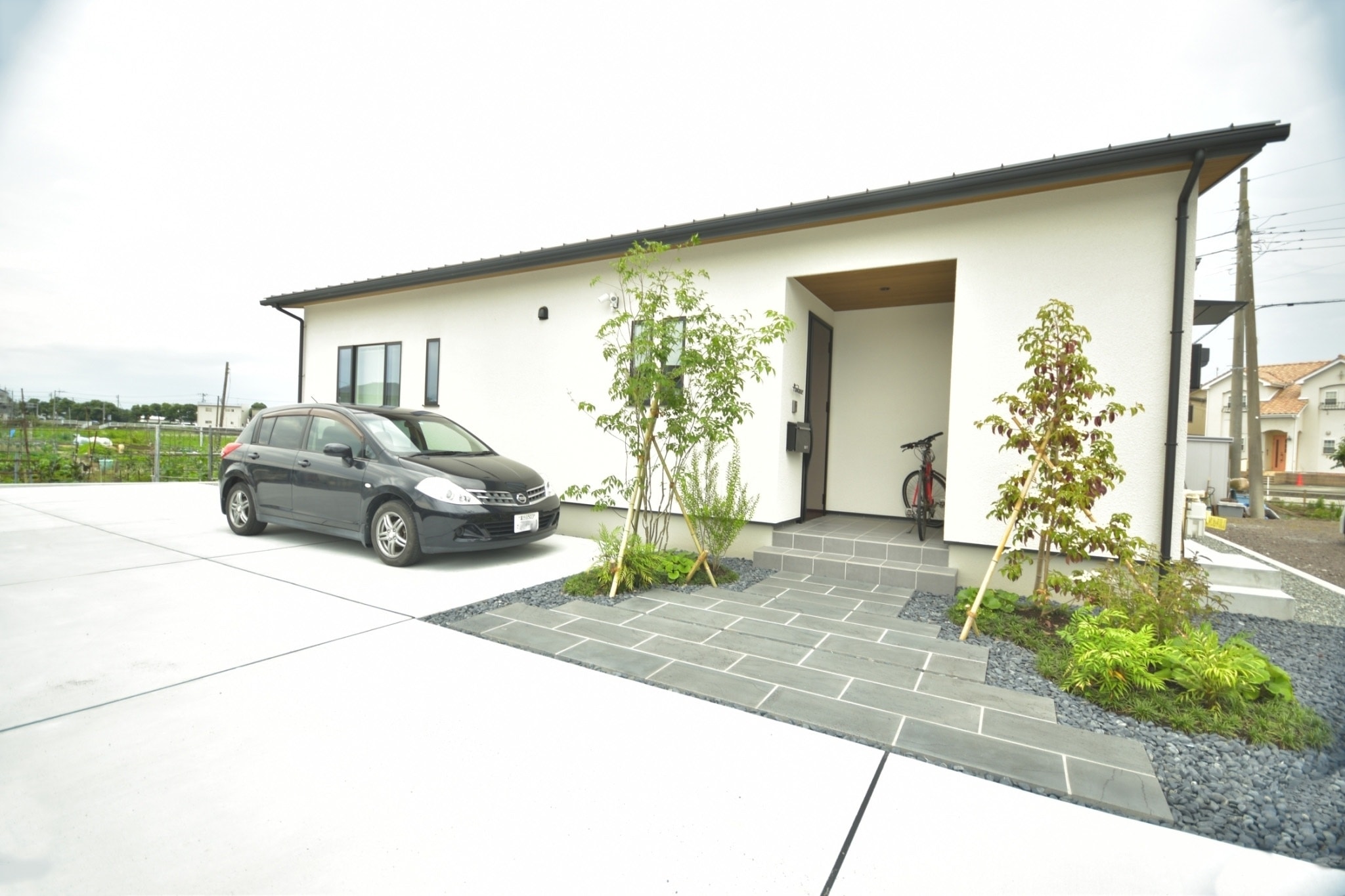 広い駐車場と石張りのアプローチのあるお庭施工事例｜THE庭や工房(ベルフィオーレ)｜富士市・エクステリア／株式会社ベルフィオーレ