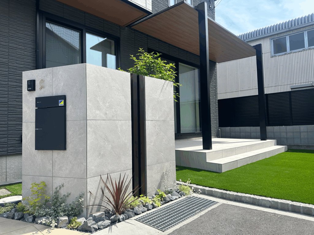 富士市の新築外構施工事例｜タイルデッキとLIXILテラスSC、三協アルミスカイリード、人工芝、タイル門柱、目隠しフェンスを組み合わせた重厚感と快適さのあるおしゃれ外構