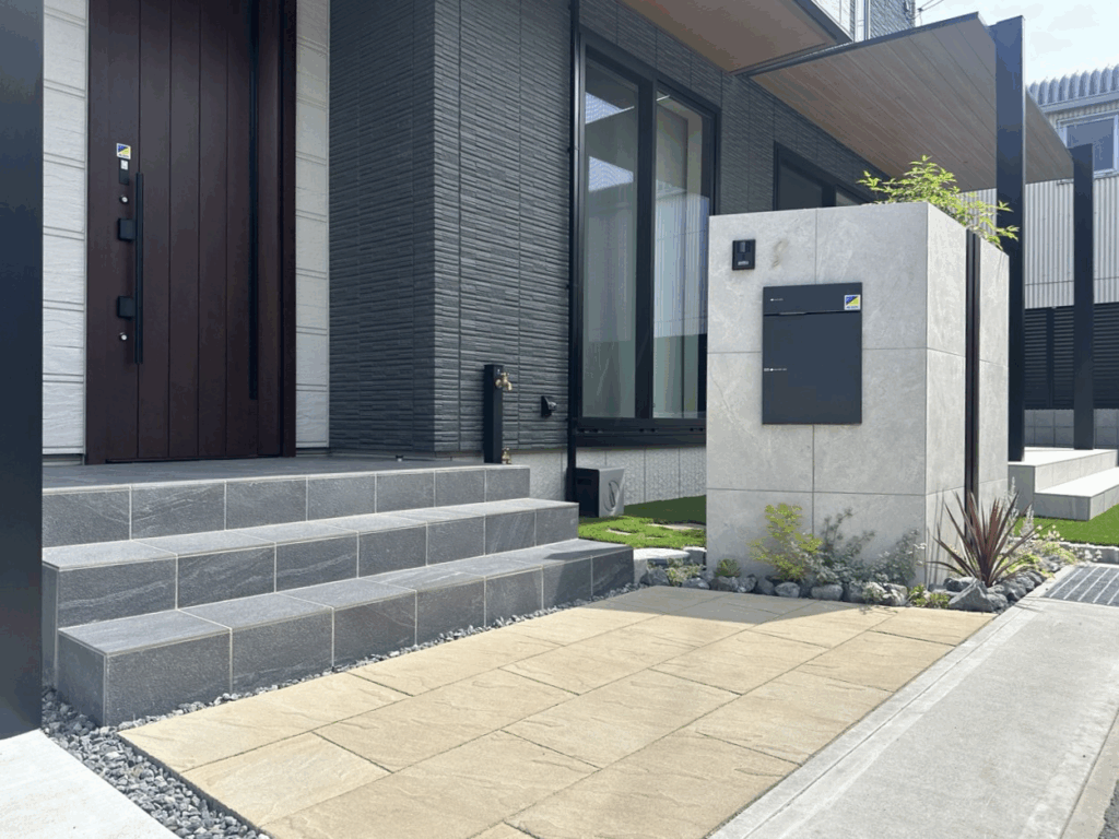 富士市の新築外構施工事例｜タイルデッキとLIXILテラスSC、三協アルミスカイリード、人工芝、タイル門柱、目隠しフェンスを組み合わせた重厚感と快適さのあるおしゃれ外構