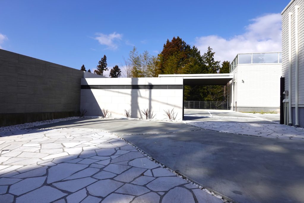 道路側からの視線をカットするためグランドアートウォールを採用したガレージ外構。