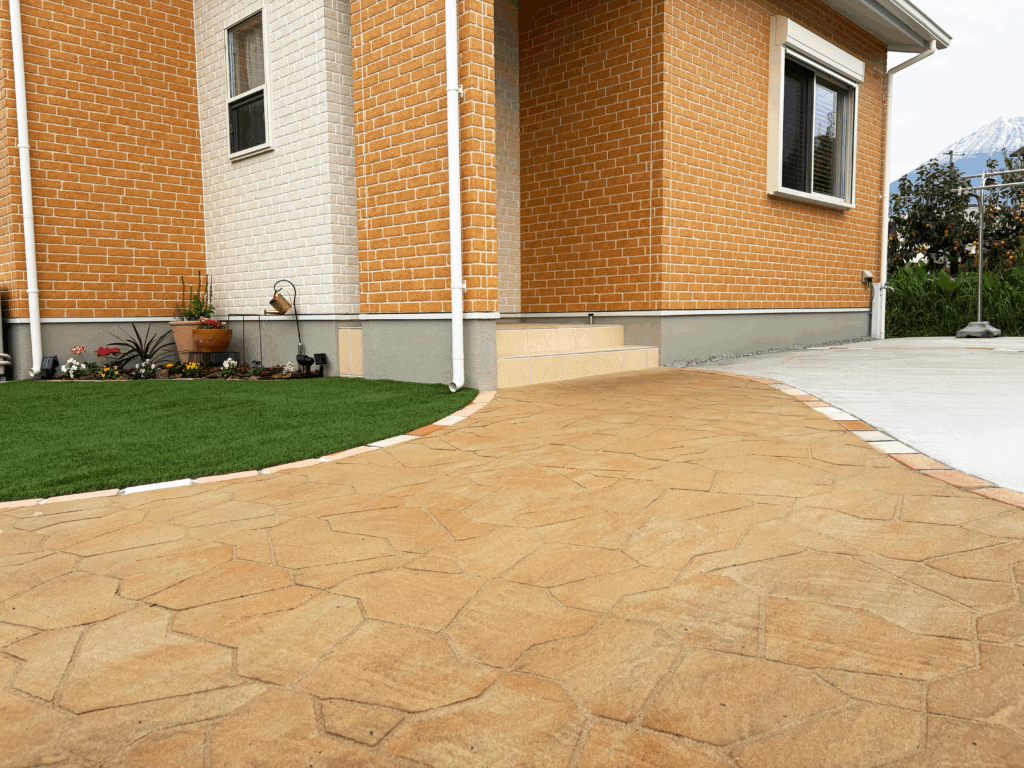 プラーガストーン（ジョイサンド・ハード）を使用した曲線アプローチ。オレンジ系カラーでやさしい印象に仕上げた富士宮市の新築外構