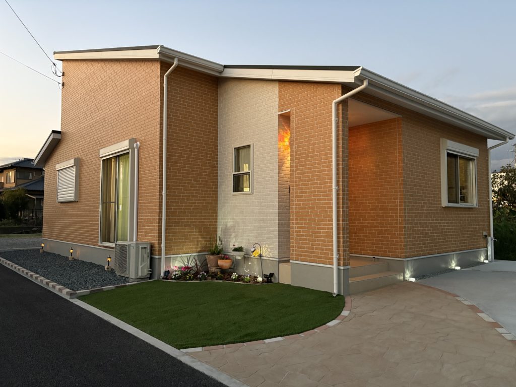 富士宮市で完成した新築外構事例。オレンジの外壁に映える曲線アプローチとナチュラルガーデンが魅力の外構デザイン