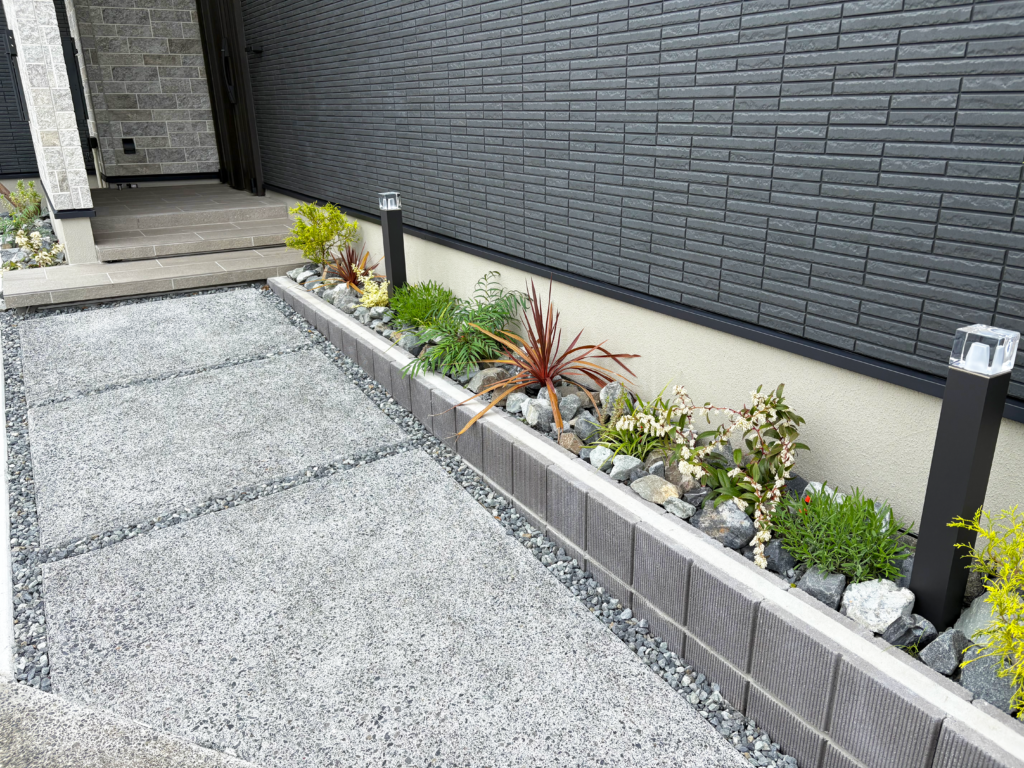 静岡市の新築外構｜洗い出しアプローチの脇に自然石・植栽・ガーデンライトを配置した玄関まわり