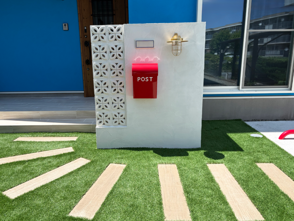 静岡市の新築外構｜花ブロックと赤いポスト、マリンライトを組み合わせた白い塗り壁門柱